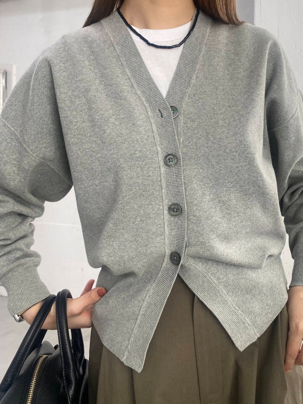 ブラック系のボストンバッグ、ブラック系のローファー、グレー系のカーディガン/ボレロを着用したレディースの春コーディネートの7枚目の写真