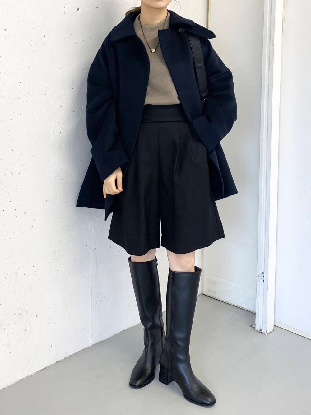 ブラック系のショルダーバッグ、ベージュ系のニット/セーター、ブラック系のその他パンツを着用したレディースの冬コーディネートの3枚目の写真