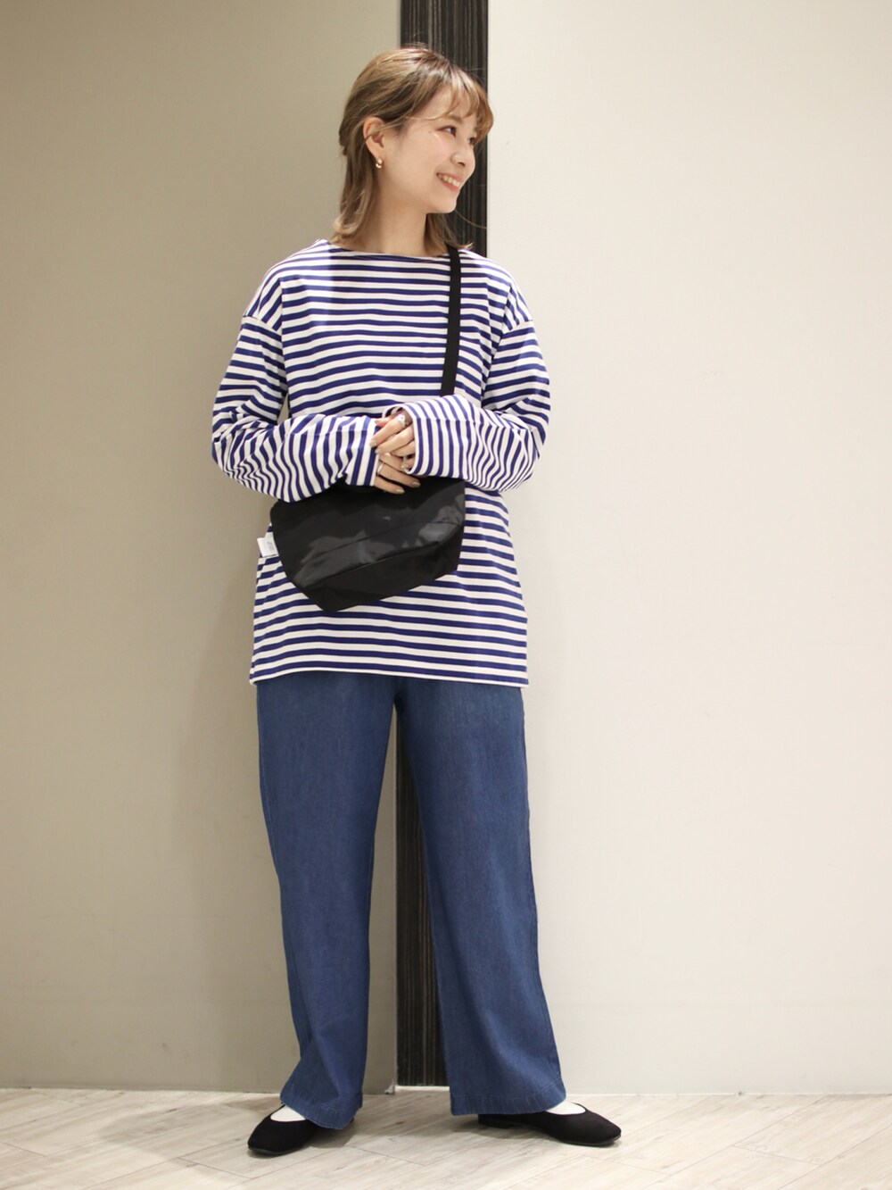 ブルー系のデニムパンツ、ブルー系のTシャツ/カットソー、ブラック系のバレエシューズを着用したレディースの冬コーディネートの2枚目の写真