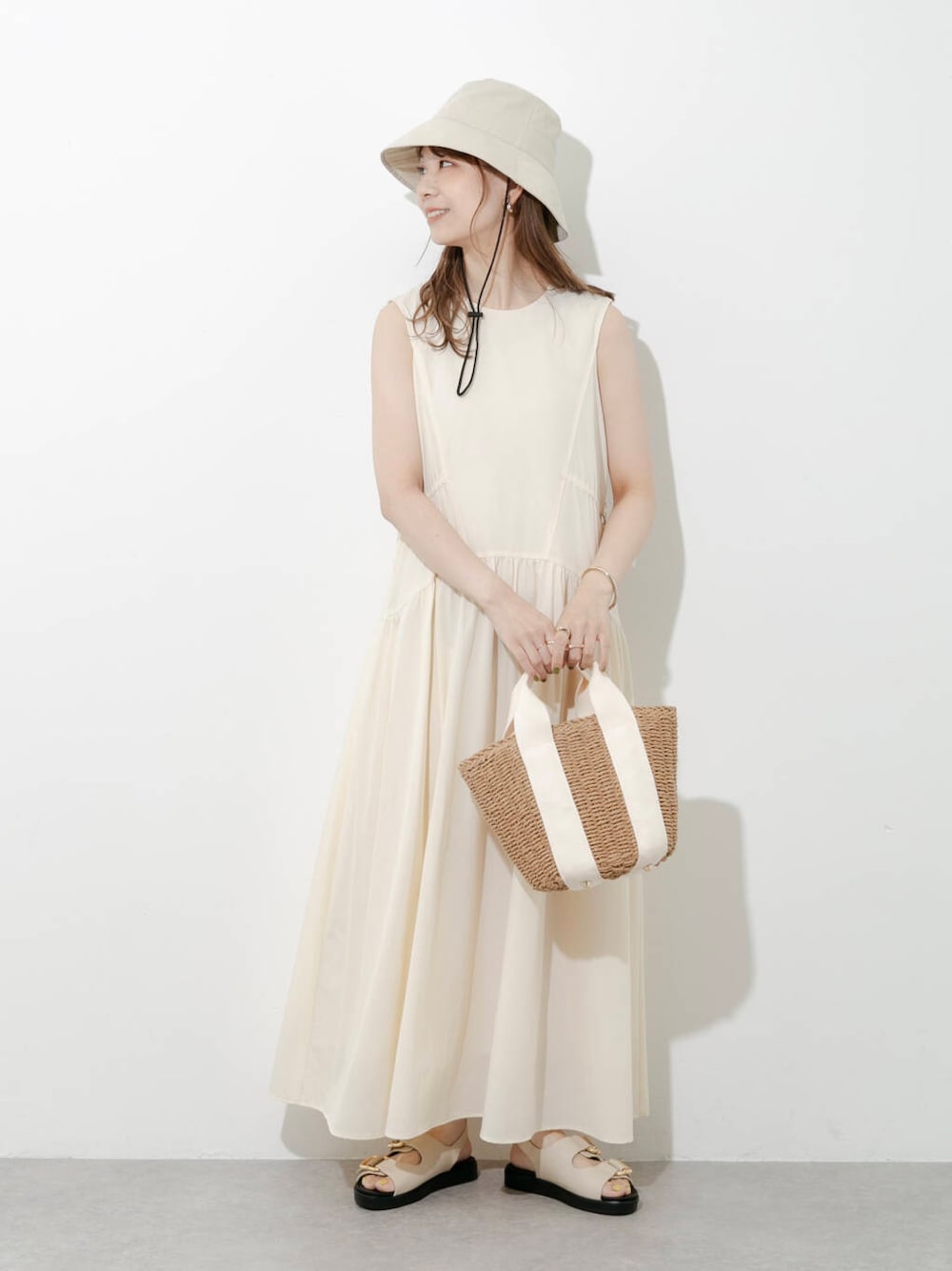 ベージュ系のハンドバッグ、グレー系のサンダル、ホワイト系のワンピースを着用したレディースの夏コーディネートの6枚目の写真