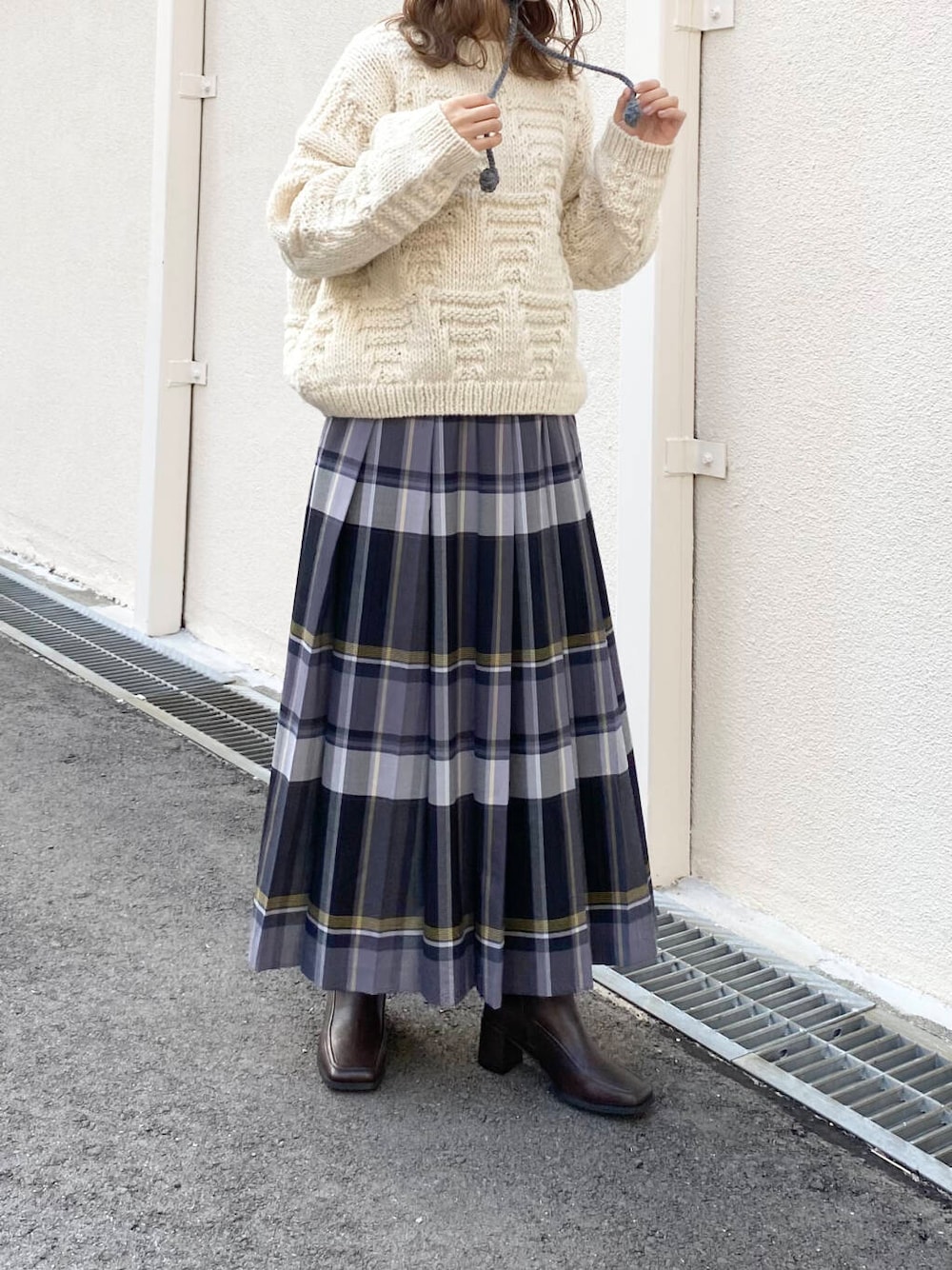 ホワイト系のニット/セーター、ブラウン系のブーツ、ブラック系のスカートを着用したレディースの冬コーディネートの5枚目の写真