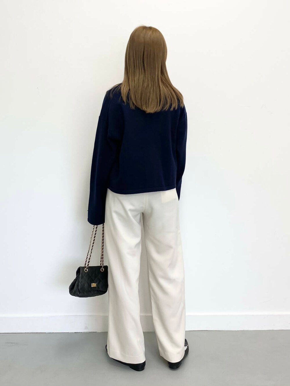 ブラック系のローファー、ブラック系のショルダーバッグ、ホワイト系のTシャツ/カットソーを着用したレディースの冬コーディネートの5枚目の写真