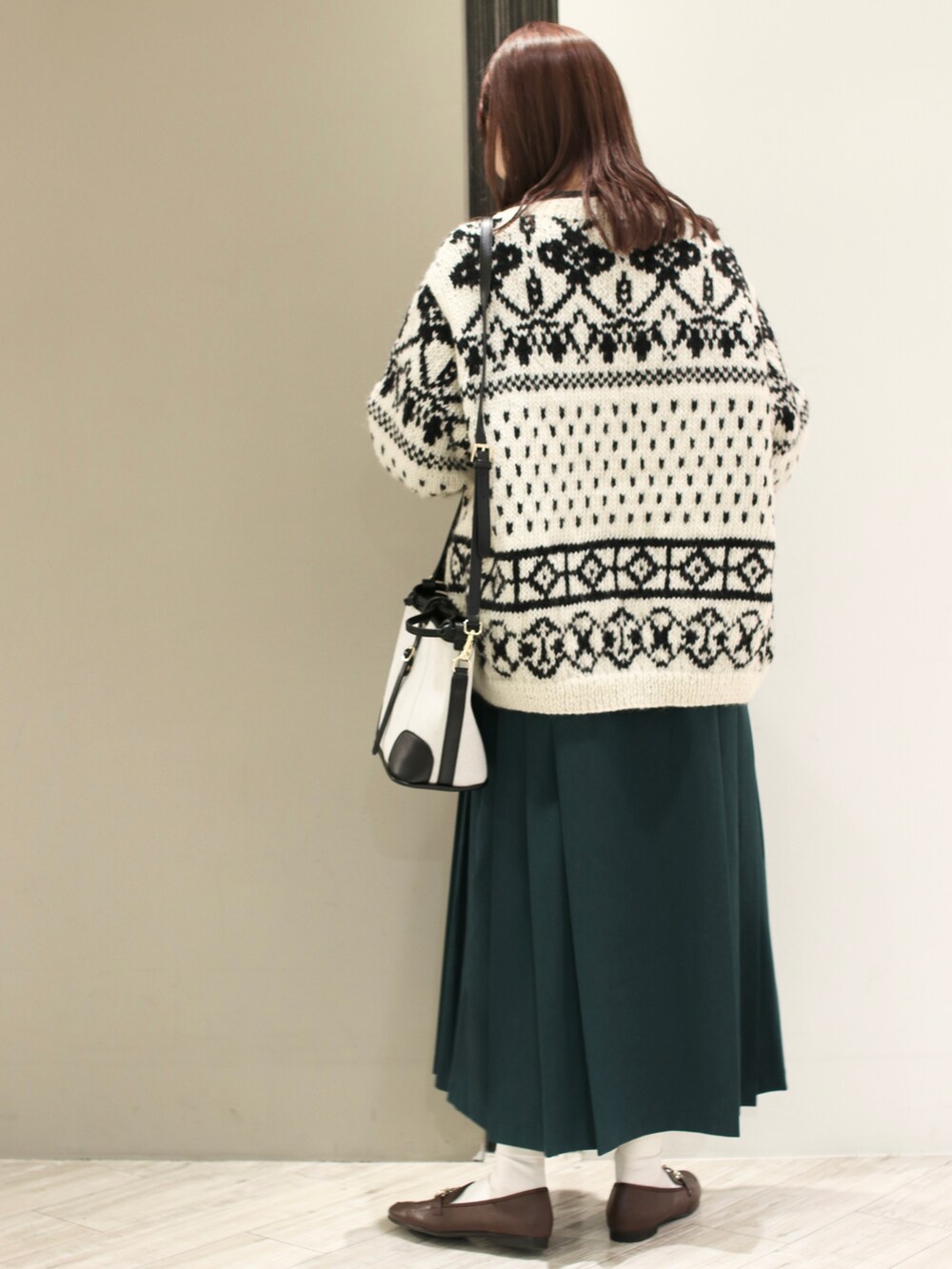 ホワイト系のカーディガン/ボレロ、グリーン系のワンピース、ブラック系のショルダーバッグを着用したレディースの冬コーディネートの4枚目の写真