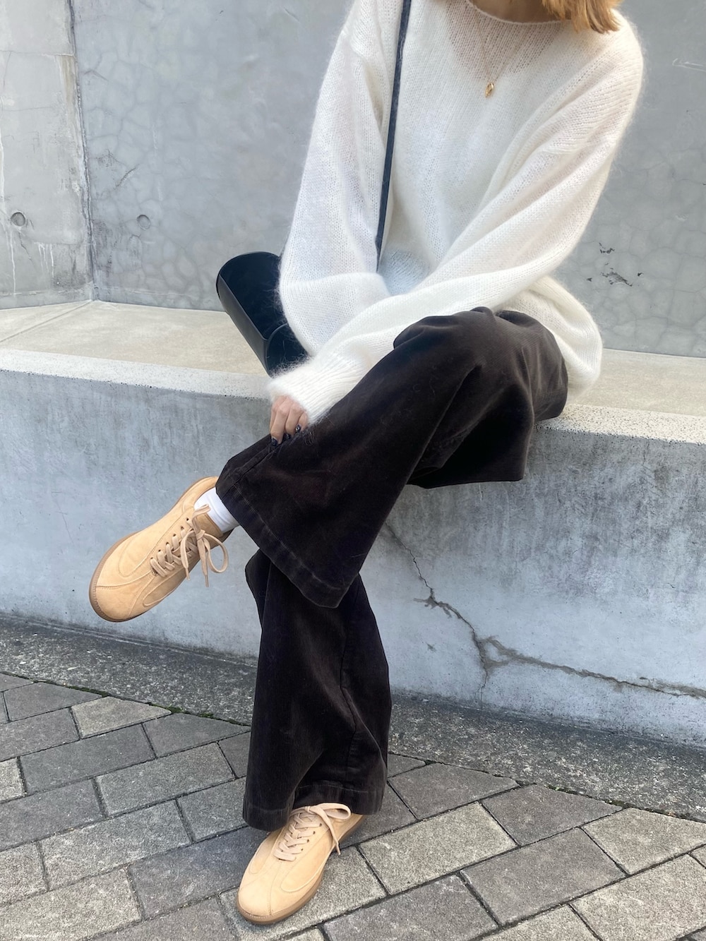 グレー系のその他パンツ、ホワイト系のニット/セーター、ベージュ系のスニーカーを着用したレディースの秋コーディネートの4枚目の写真