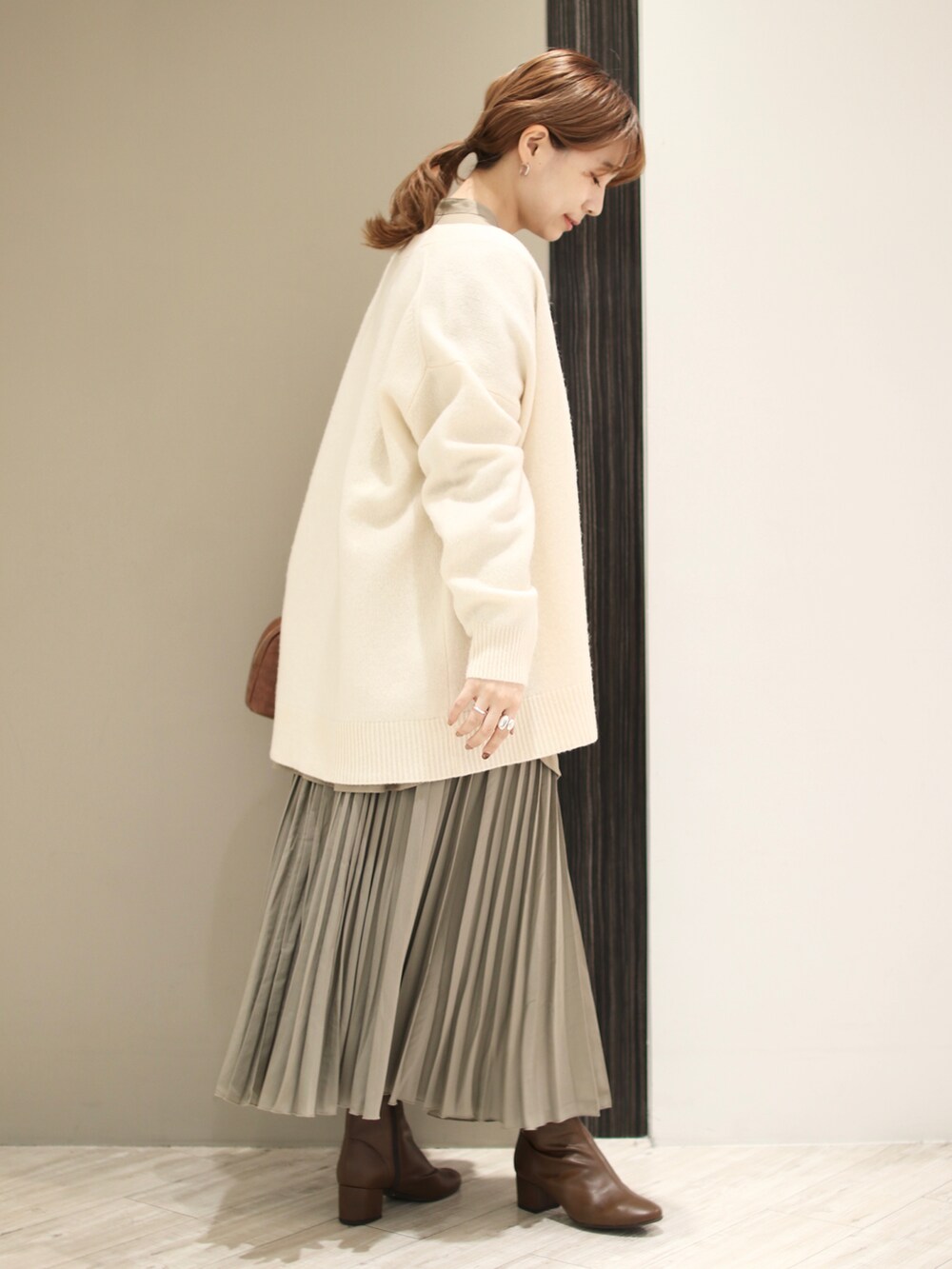 ホワイト系のカーディガン/ボレロ、グレー系のシャツ/ブラウス、ブラウン系のショルダーバッグを着用したレディースの秋コーディネートの3枚目の写真