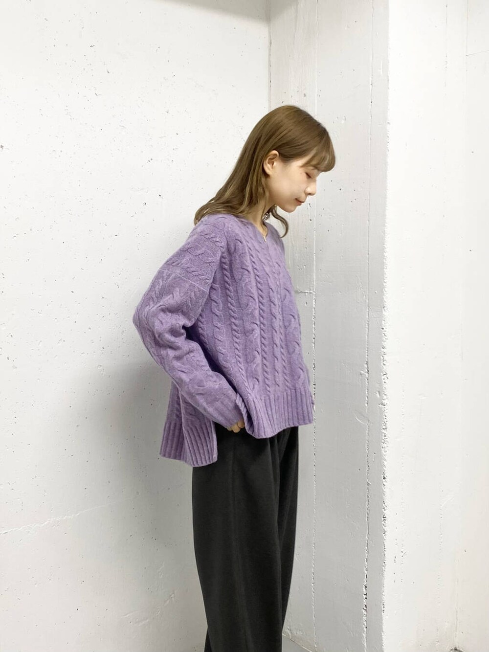 パープル系のニット/セーター、グレー系のその他パンツ、ブラック系のブーツを着用したレディースの秋コーディネートの3枚目の写真