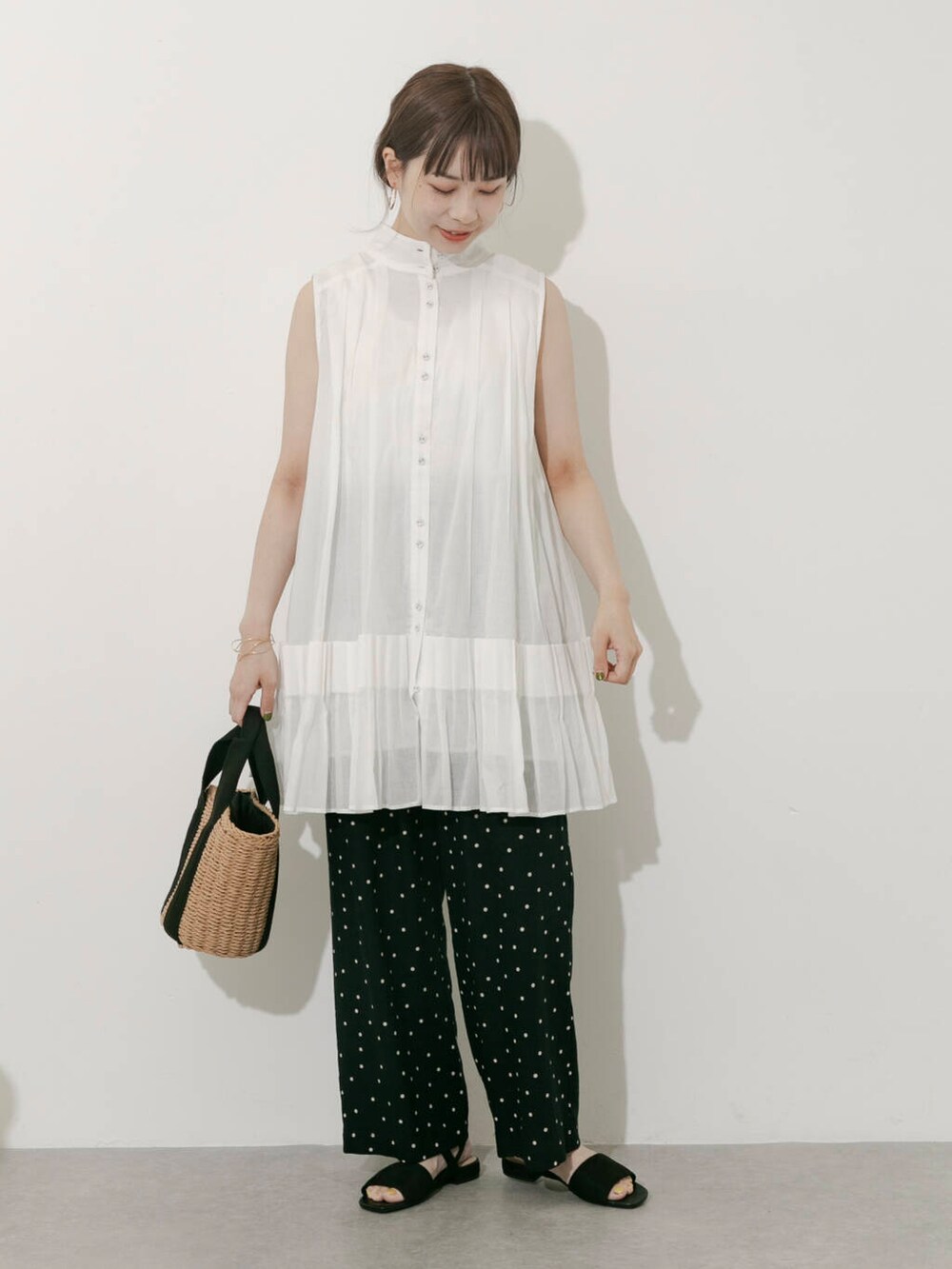 ベージュ系のハンドバッグ、ブラック系のその他パンツ、ホワイト系のワンピースを着用したレディースの夏コーディネートの5枚目の写真