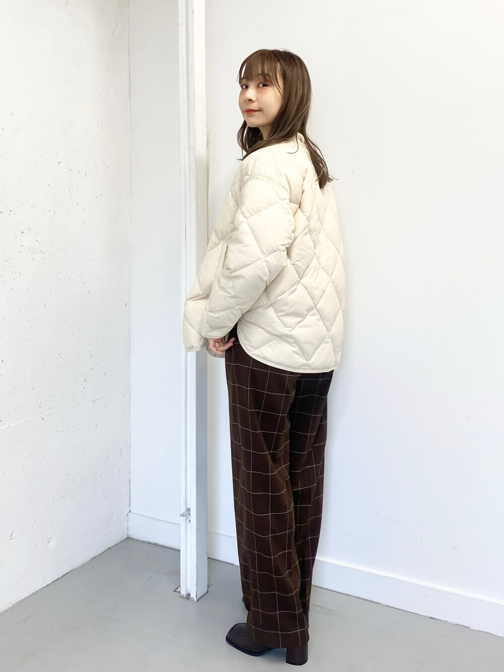 ブラウン系のブーツ、ブラウン系のその他パンツ、ホワイト系のダウンジャケット/コートを着用したレディースの冬コーディネートの4枚目の写真