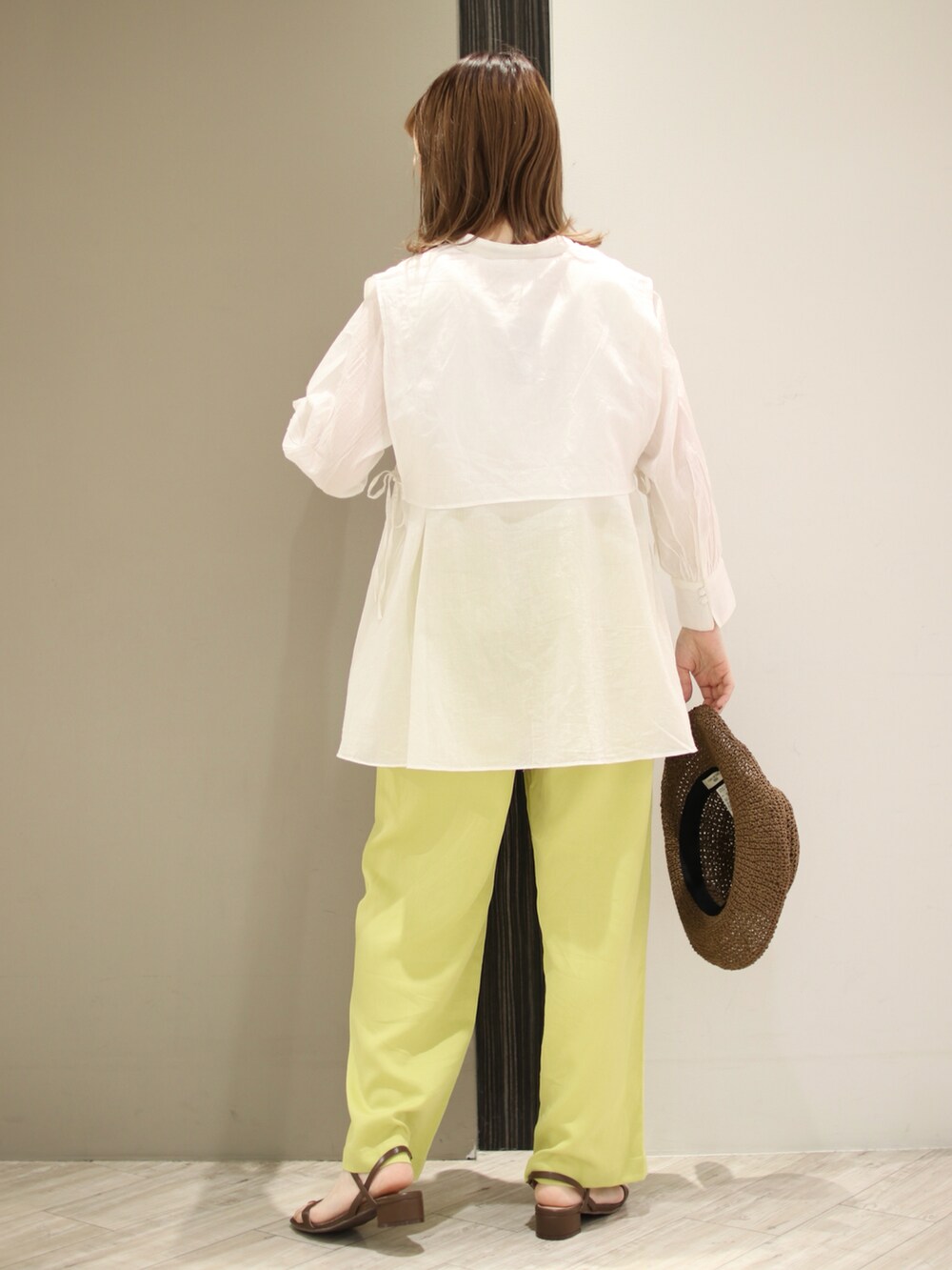 イエロー系のその他パンツ、ホワイト系のシャツ/ブラウス、ブラウン系のサンダルを着用したレディースの春コーディネートの3枚目の写真