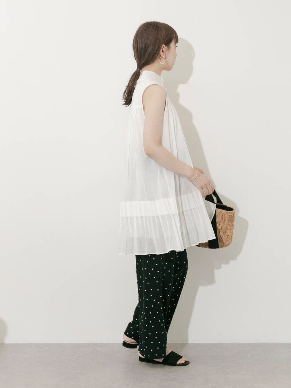 ベージュ系のハンドバッグ、ブラック系のその他パンツ、ホワイト系のワンピースを着用したレディースの夏コーディネートの6枚目の写真