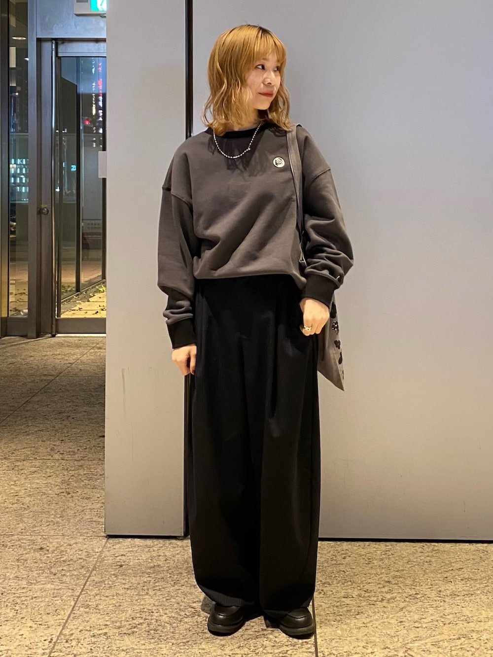 グレー系のトートバッグ、グレー系のスウェットを着用したレディースの春コーディネートの2枚目の写真