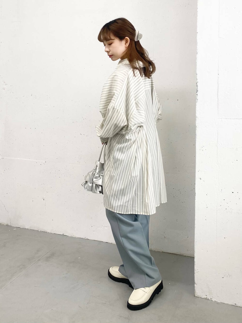 ブルー系のその他パンツ、ホワイト系のローファー、シルバー系のハンドバッグを着用したレディースの春コーディネートの2枚目の写真