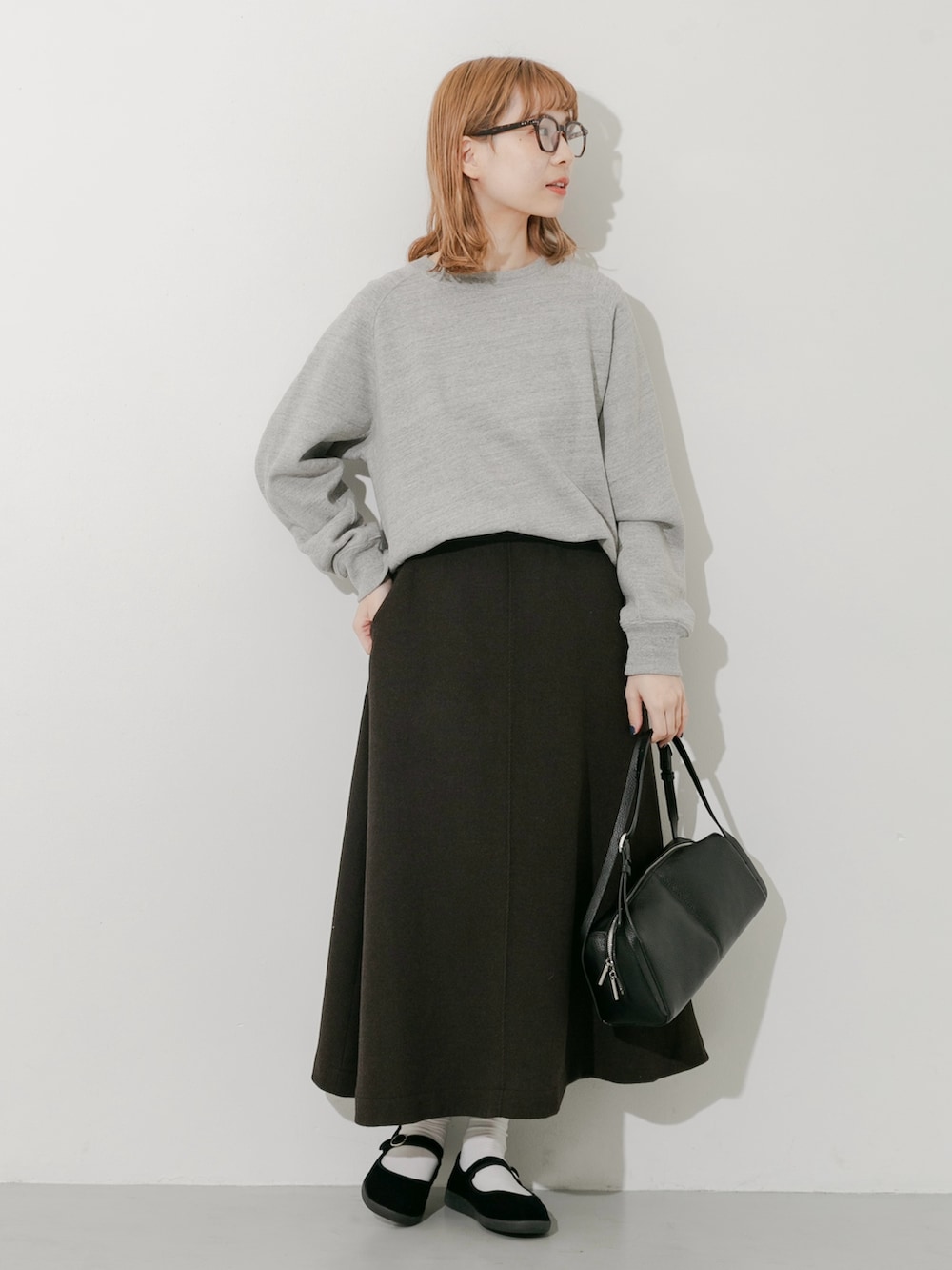 グレー系のスカート、ブラック系のその他シューズ、グレー系のスウェットを着用したレディースの秋コーディネートの6枚目の写真
