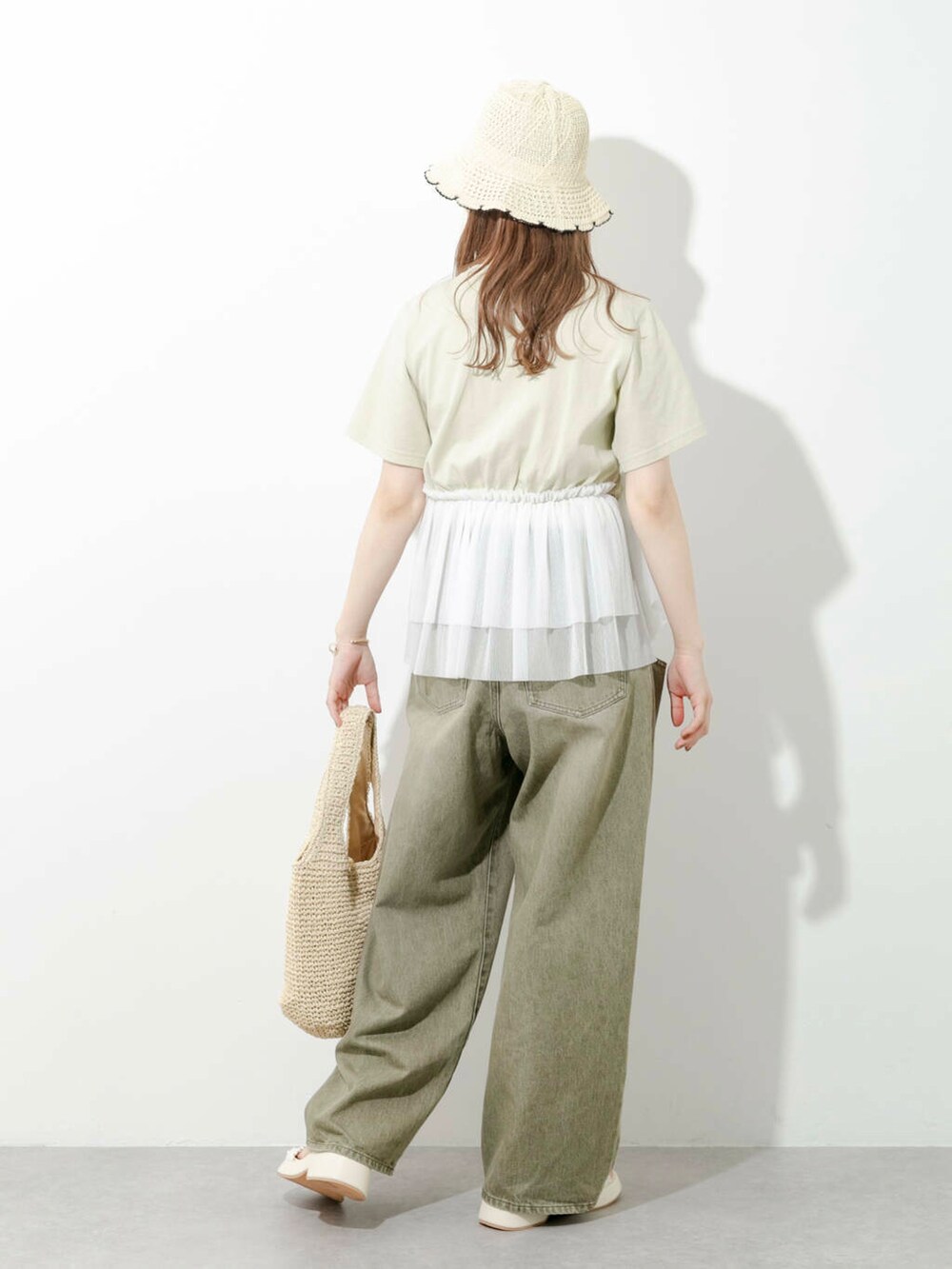 ベージュ系のトートバッグ、グリーン系のTシャツ/カットソー、ホワイト系のサンダルを着用したレディースの夏コーディネートの5枚目の写真