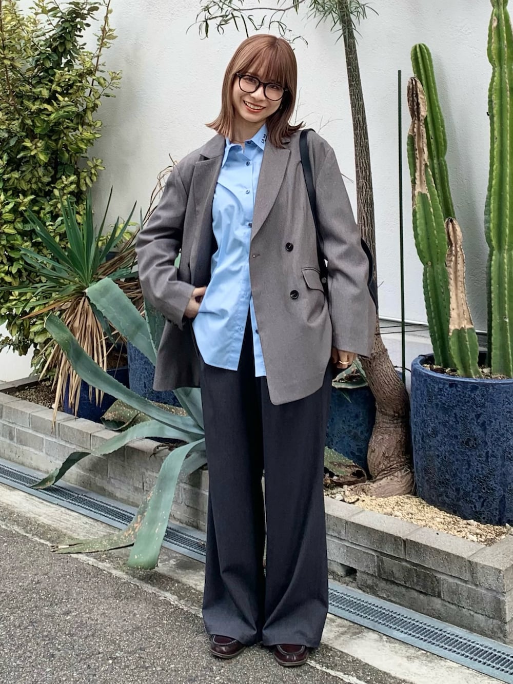 ブラック系のショルダーバッグ、グレー系のその他アウター、ブルー系のシャツ/ブラウスを着用したレディースの秋コーディネートの2枚目の写真