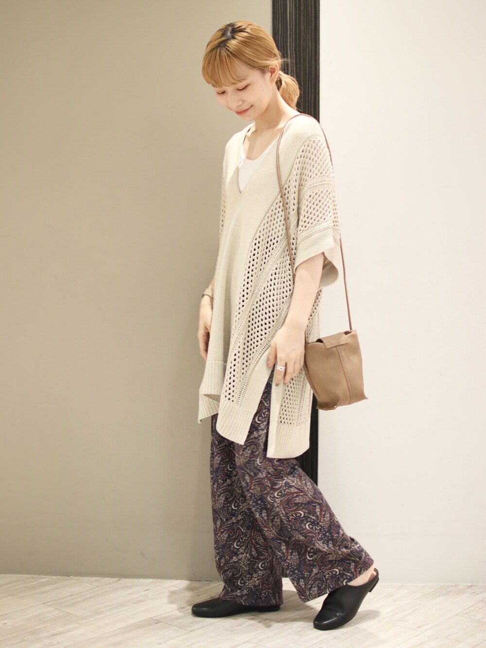 ブルー系のその他パンツ、ベージュ系のニット/セーター、ホワイト系のタンクトップを着用したレディースの秋コーディネートの5枚目の写真