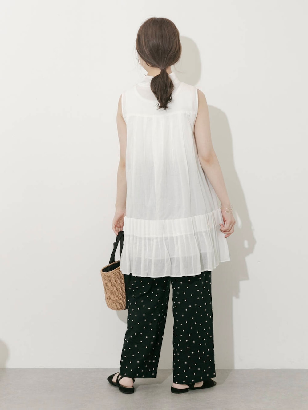 ベージュ系のハンドバッグ、ブラック系のその他パンツ、ホワイト系のワンピースを着用したレディースの夏コーディネートの2枚目の写真