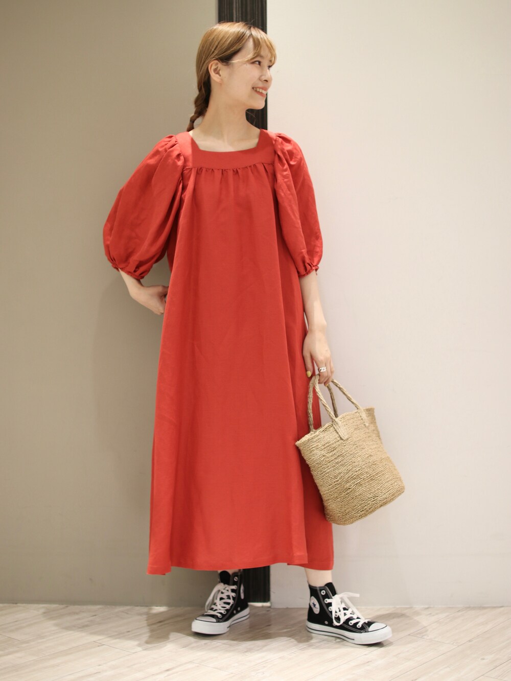 グリーン系のトートバッグ、レッド系のワンピース、ブラック系のスニーカーを着用したレディースの夏コーディネートの2枚目の写真