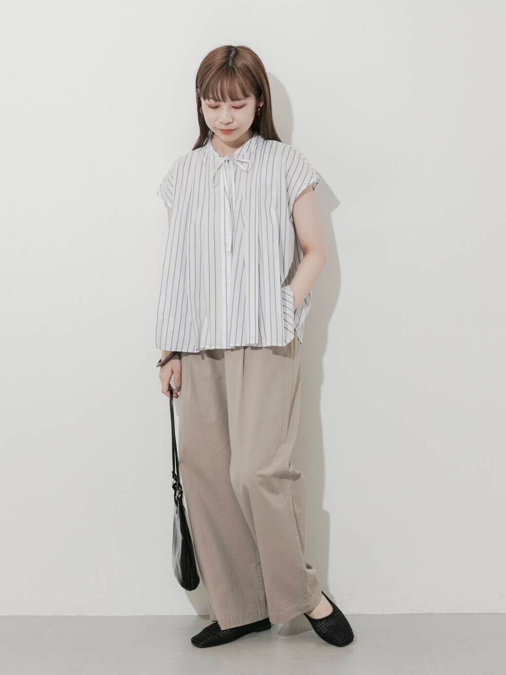 ベージュ系のその他パンツ、ブラック系のショルダーバッグ、ブラック系のバレエシューズを着用したレディースの夏コーディネートの5枚目の写真