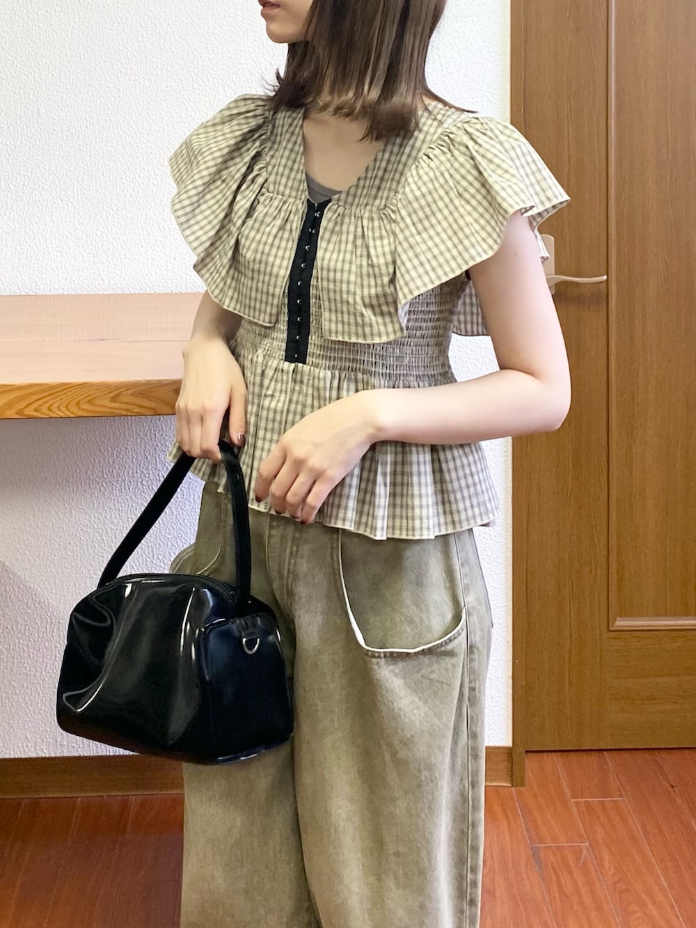 ブラック系のトートバッグ、ベージュ系のシャツ/ブラウス、ホワイト系のパンプスを着用したレディースの春コーディネートの4枚目の写真