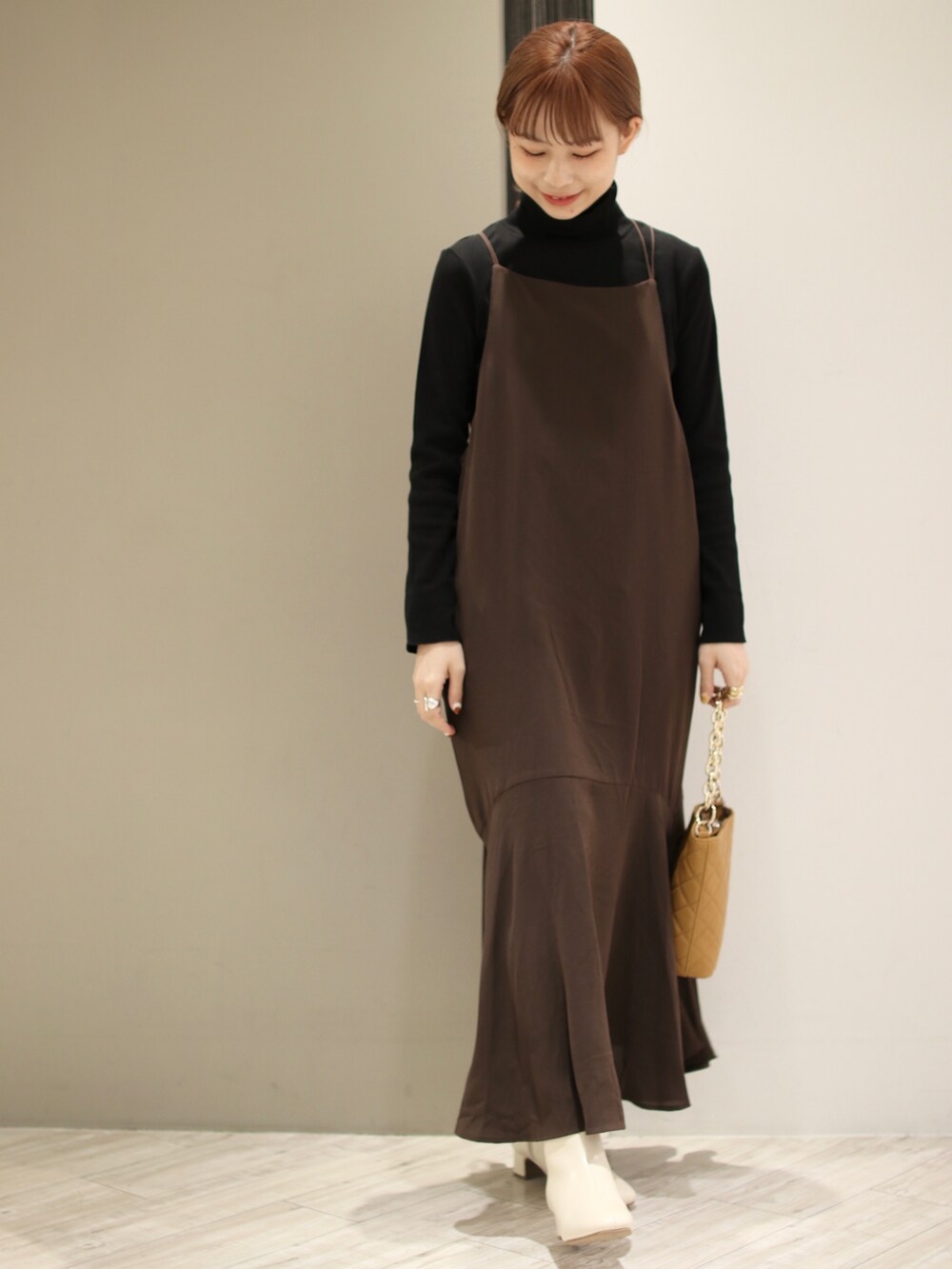 ベージュ系のショルダーバッグ、ベージュ系のブーツ、ブラック系のTシャツ/カットソーを着用したレディースの秋コーディネートの4枚目の写真