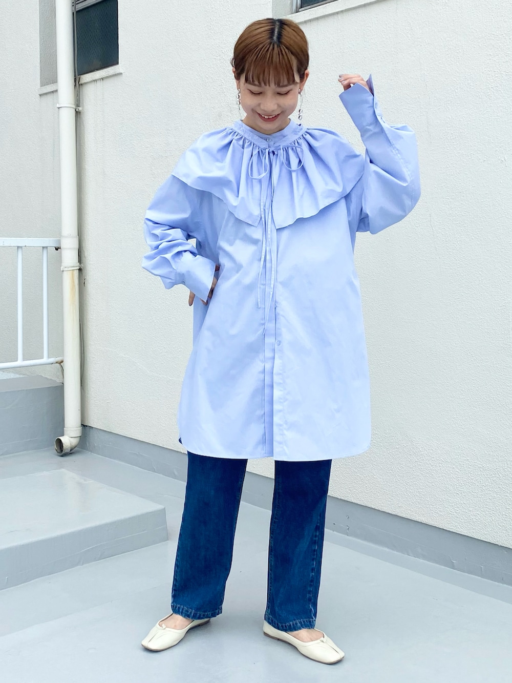 ブルー系のデニムパンツ、パープル系のワンピース、ホワイト系のバレエシューズを着用したレディースの秋コーディネートの4枚目の写真