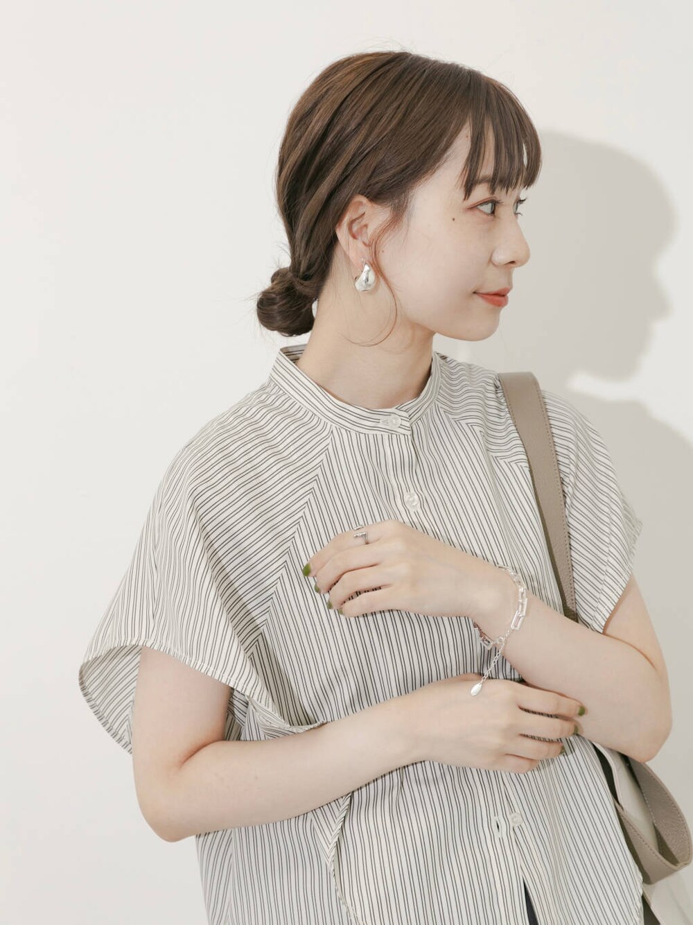 グレー系のスカート、ホワイト系のシャツ/ブラウス、シルバー系のサンダルを着用したレディースの夏コーディネートの5枚目の写真