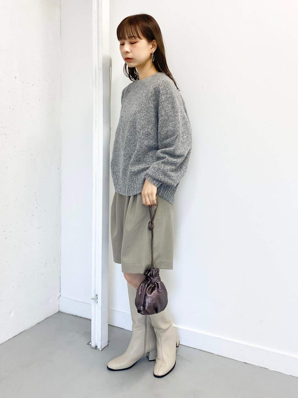 グレー系のニット/セーター、ベージュ系のその他パンツ、ホワイト系のブーツを着用したレディースの冬コーディネートの3枚目の写真