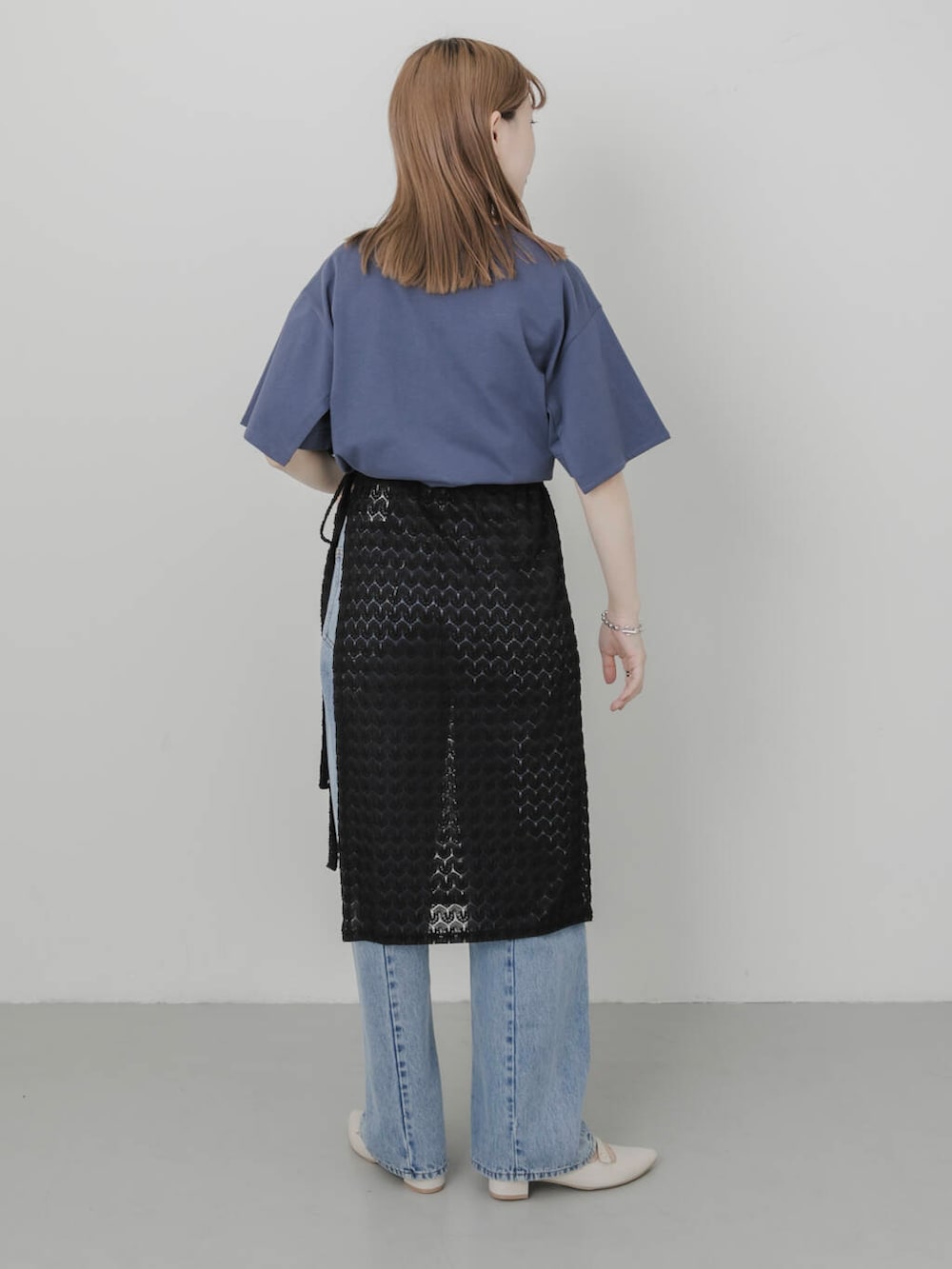 ブルー系のデニムパンツ、ホワイト系のパンプス、ブラック系のスカートを着用したレディースの夏コーディネートの6枚目の写真