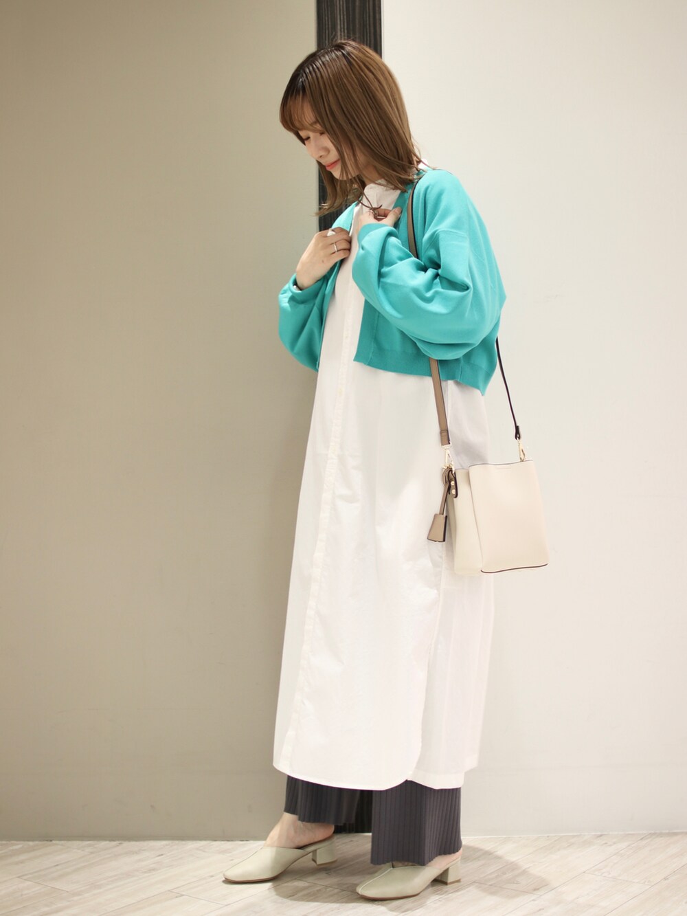 グリーン系のカーディガン/ボレロ、ホワイト系のワンピース、グレー系のその他パンツを着用したレディースの冬コーディネートの2枚目の写真