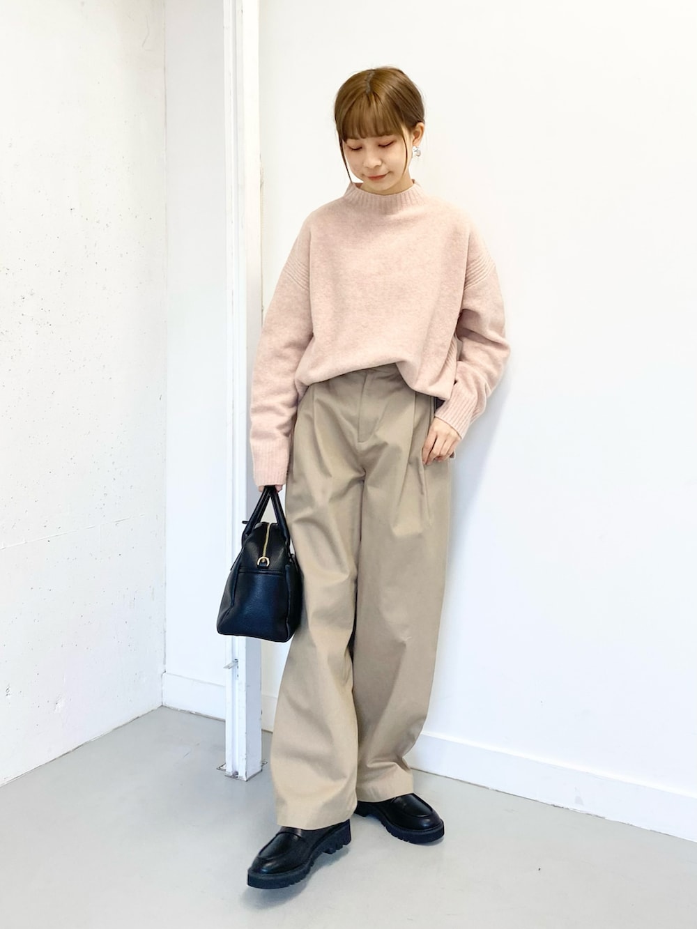 ブラック系のボストンバッグ、ブラック系のローファー、ベージュ系のその他パンツを着用したレディースの冬コーディネートの2枚目の写真