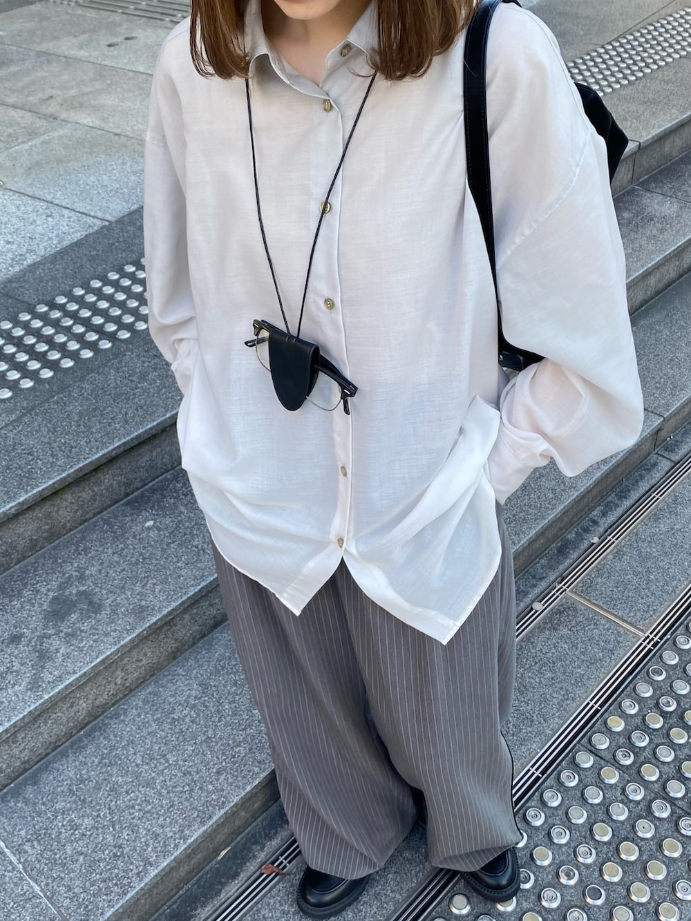 ブラック系のトートバッグ、ブラック系のローファー、グレー系のその他パンツを着用したレディースの春コーディネートの6枚目の写真