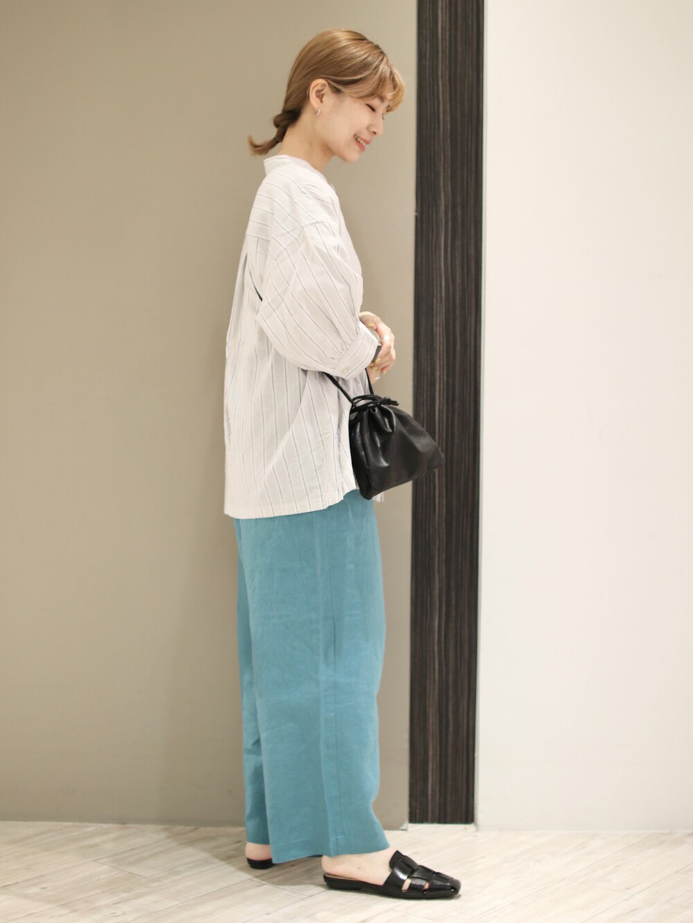 ブラック系のサンダル、ブルー系のその他パンツ、ブラック系のショルダーバッグを着用したレディースの夏コーディネートの3枚目の写真