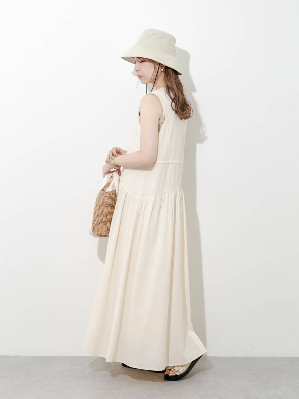 ベージュ系のハンドバッグ、グレー系のサンダル、ホワイト系のワンピースを着用したレディースの夏コーディネートの4枚目の写真