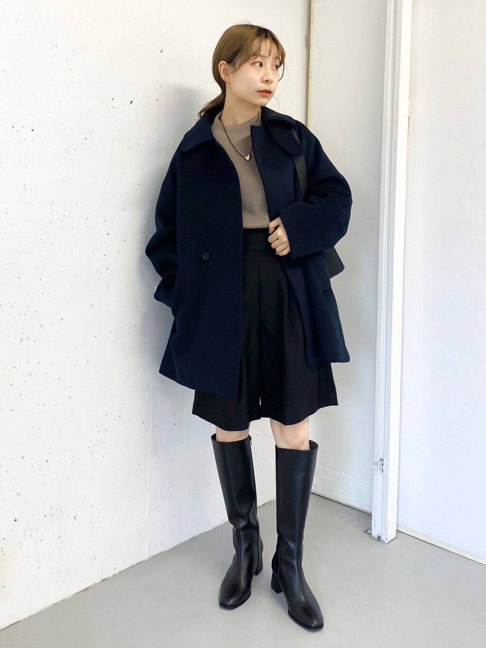 ブラック系のショルダーバッグ、ベージュ系のニット/セーター、ブラック系のその他パンツを着用したレディースの冬コーディネートの2枚目の写真