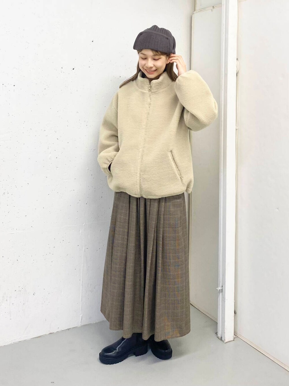 ブラック系のブーツ、その他のスカート、ホワイト系のブルゾンを着用したレディースの秋コーディネートの6枚目の写真