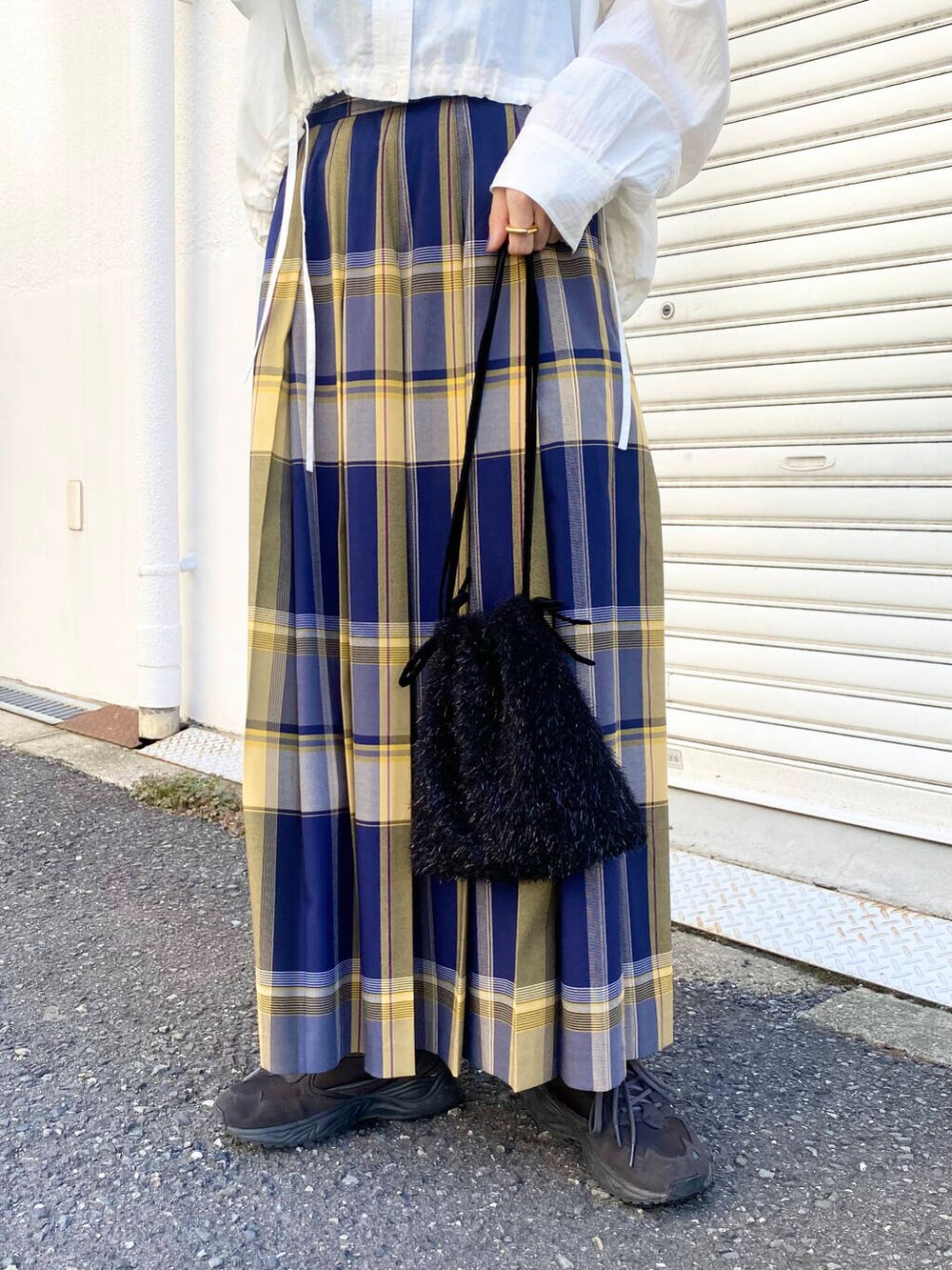 グレー系のスニーカー、ホワイト系のシャツ/ブラウス、ブルー系のスカートを着用したレディースの秋コーディネートの6枚目の写真