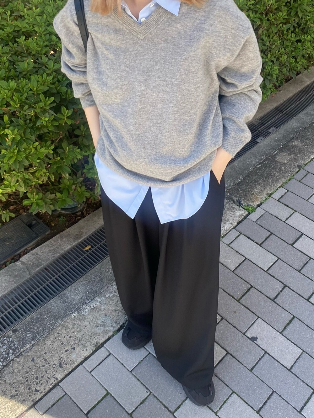 ブルー系のシャツ/ブラウス、ブラック系のボストンバッグ、グレー系のニット/セーターを着用したレディースの秋コーディネートの5枚目の写真