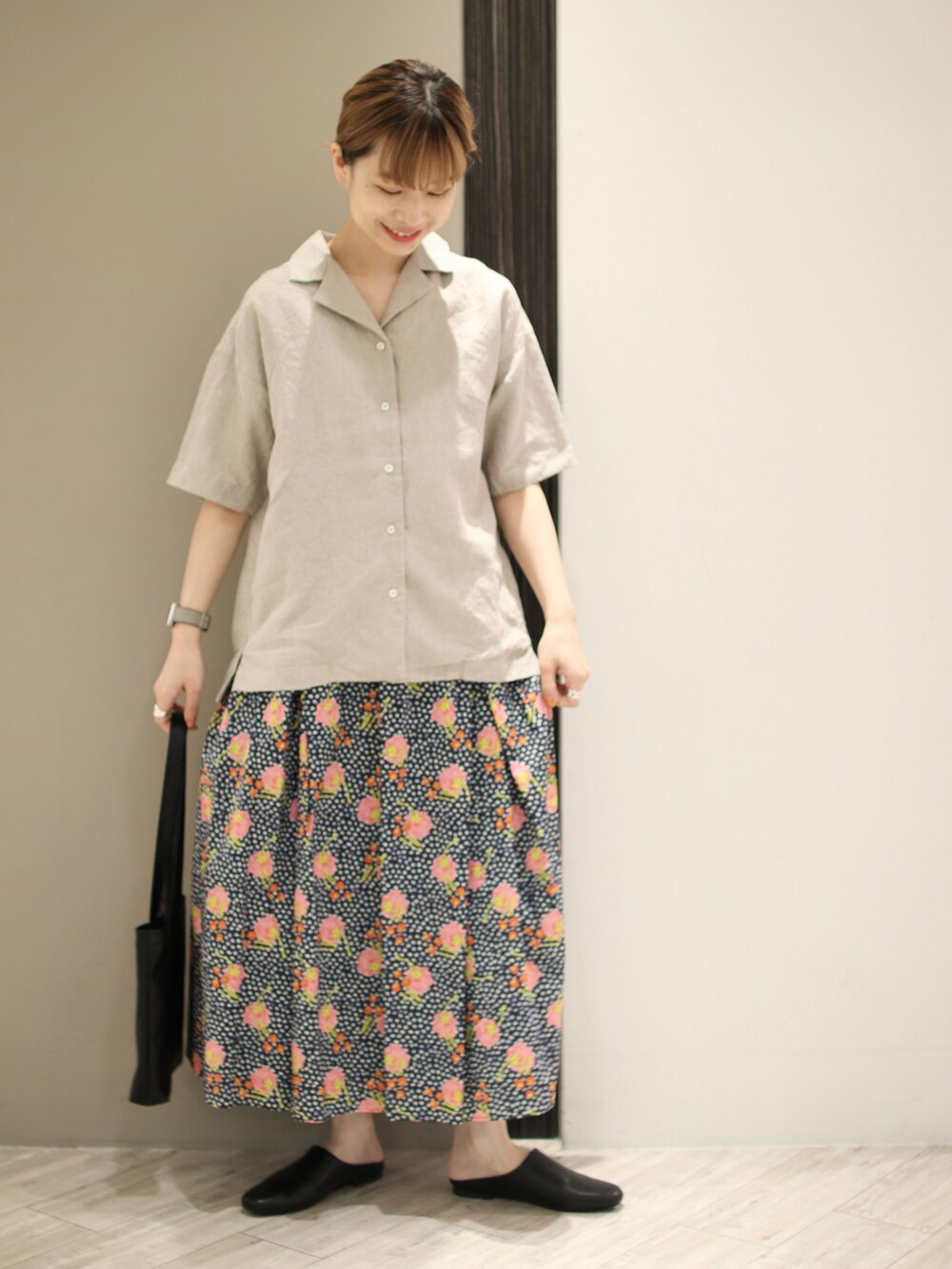 ベージュ系のTシャツ/カットソー、ブルー系のスカート、ブラック系のトートバッグを着用したレディースの夏コーディネートの3枚目の写真