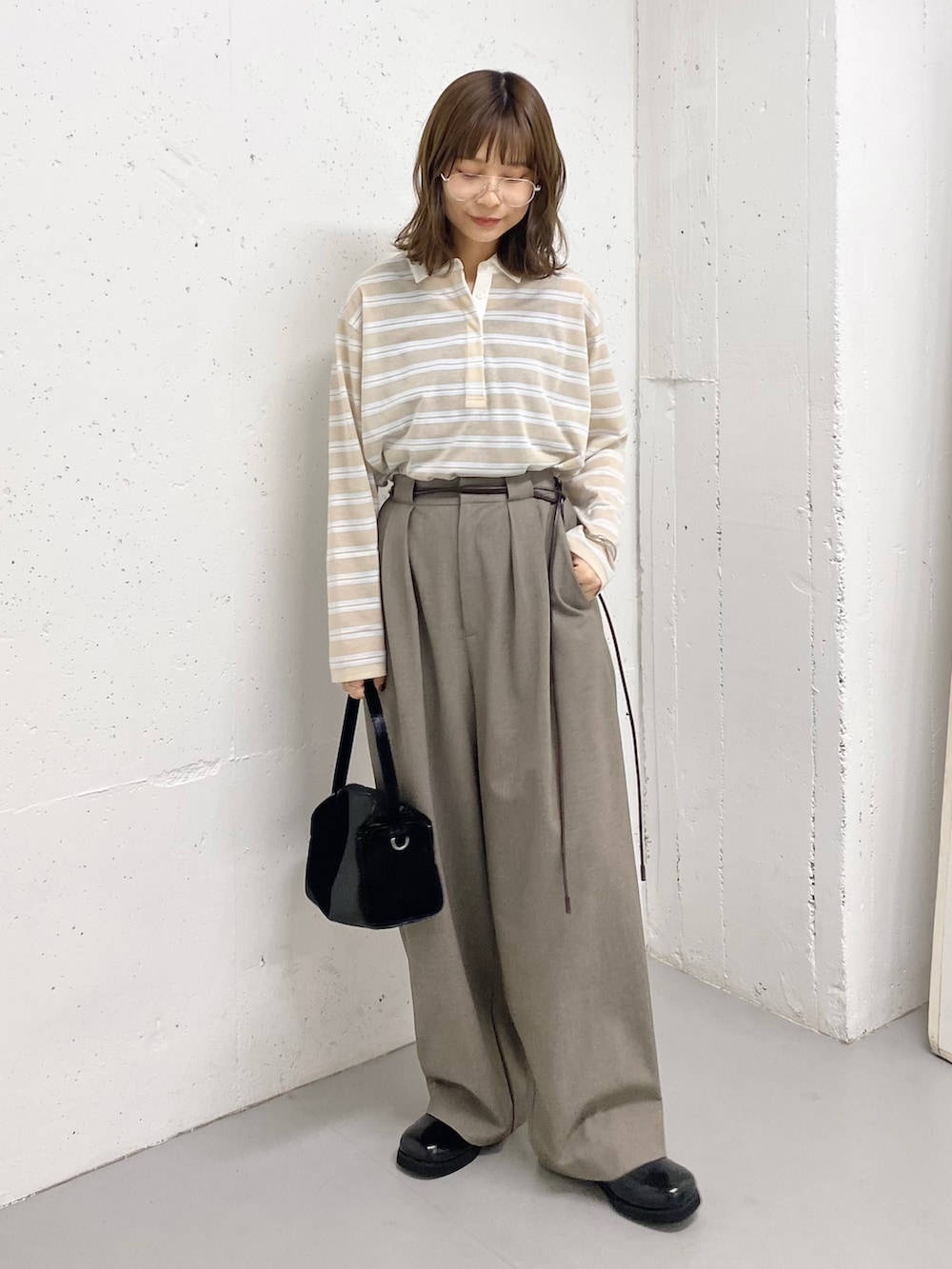 ブラック系のトートバッグ、ベージュ系のシャツ/ブラウス、ブラック系のサンダルを着用したレディースの春コーディネートの2枚目の写真