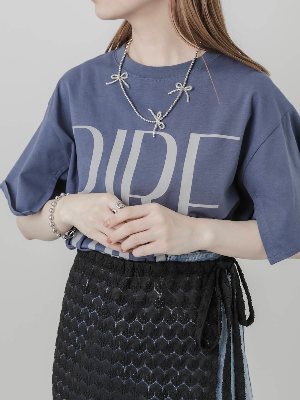 ブルー系のデニムパンツ、ホワイト系のパンプス、ブラック系のスカートを着用したレディースの夏コーディネートの5枚目の写真