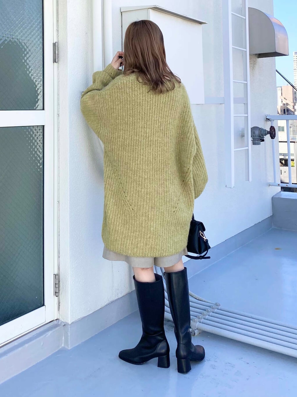 ブラック系のショルダーバッグ、ベージュ系のその他パンツ、グリーン系のワンピースを着用したレディースの秋コーディネートの5枚目の写真