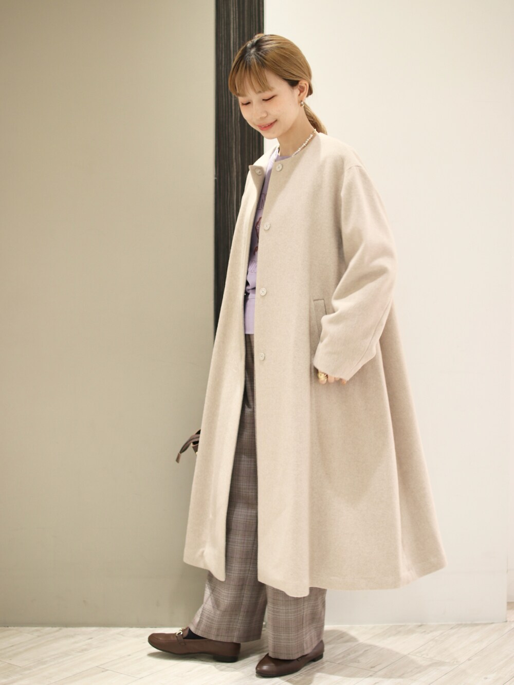 ブラウン系のハンドバッグ、パープル系のスウェット、ベージュ系のその他アウターを着用したレディースの冬コーディネートの3枚目の写真