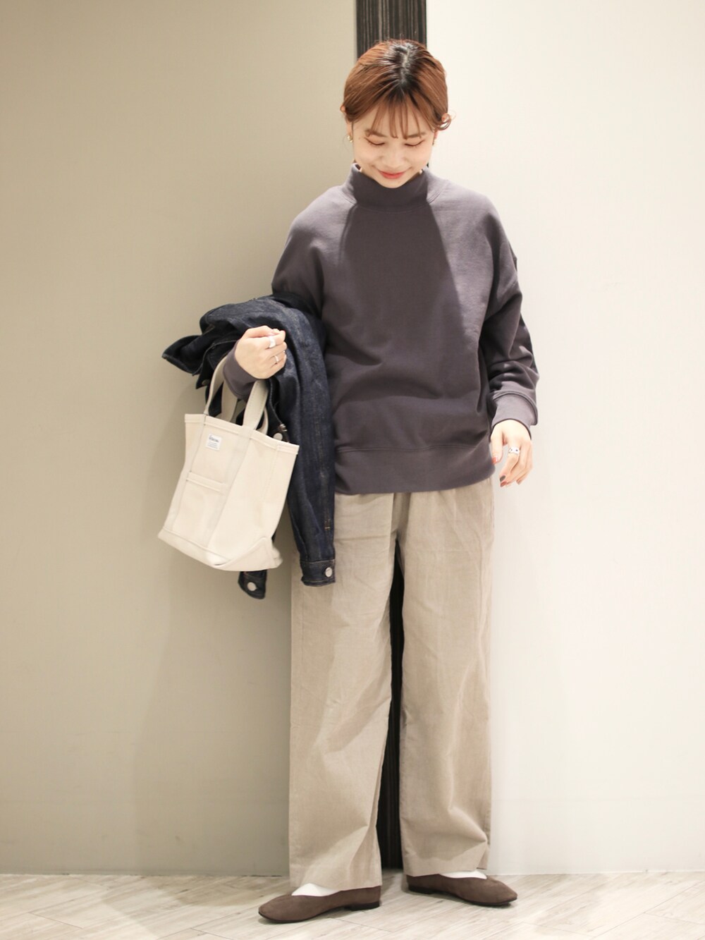 グレー系のその他パンツ、パープル系のスウェット、ホワイト系のトートバッグを着用したレディースの冬コーディネートの3枚目の写真