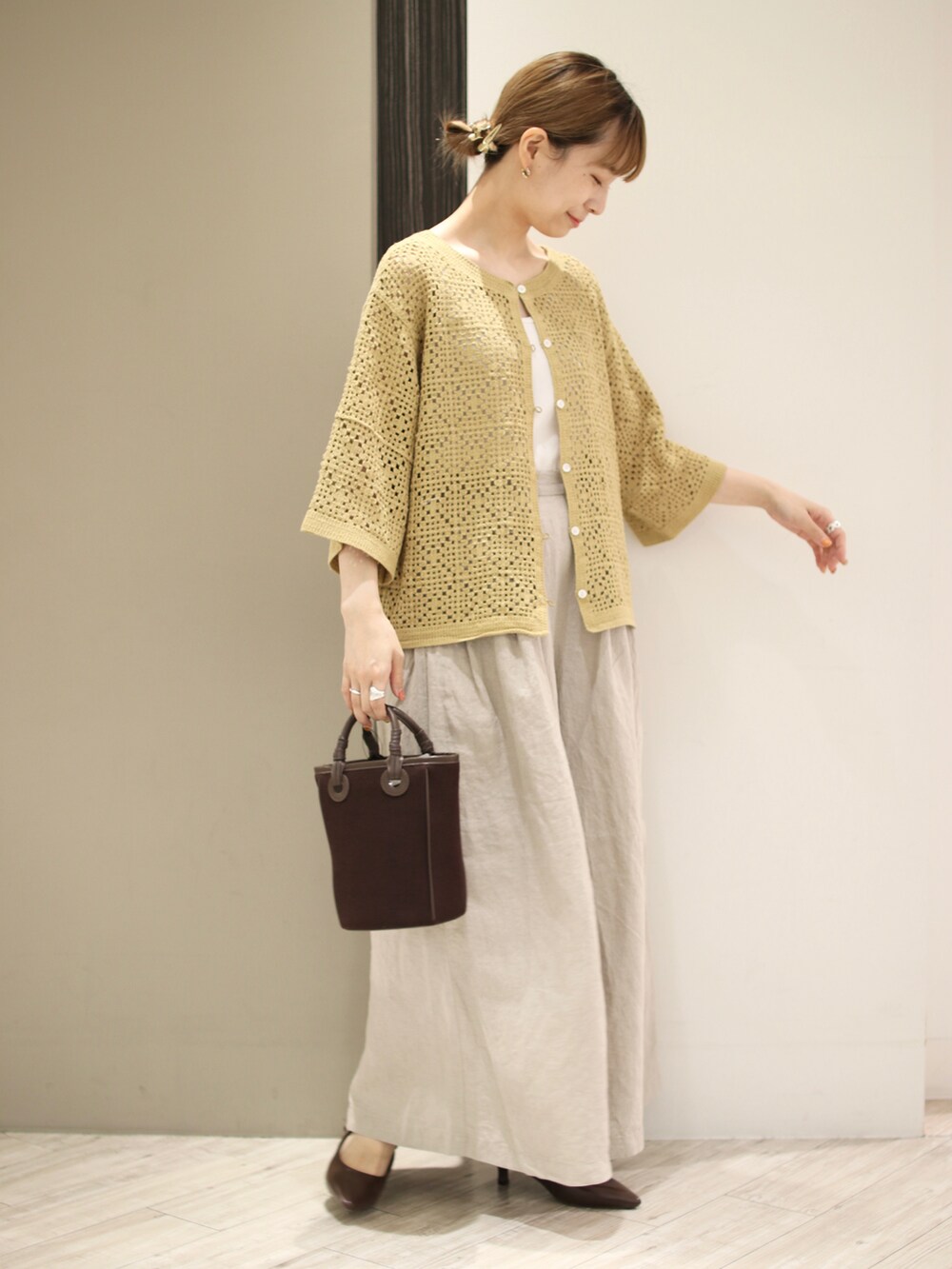 ホワイト系のタンクトップ、イエロー系のカーディガン/ボレロ、ベージュ系のその他パンツを着用したレディースの夏コーディネートの4枚目の写真
