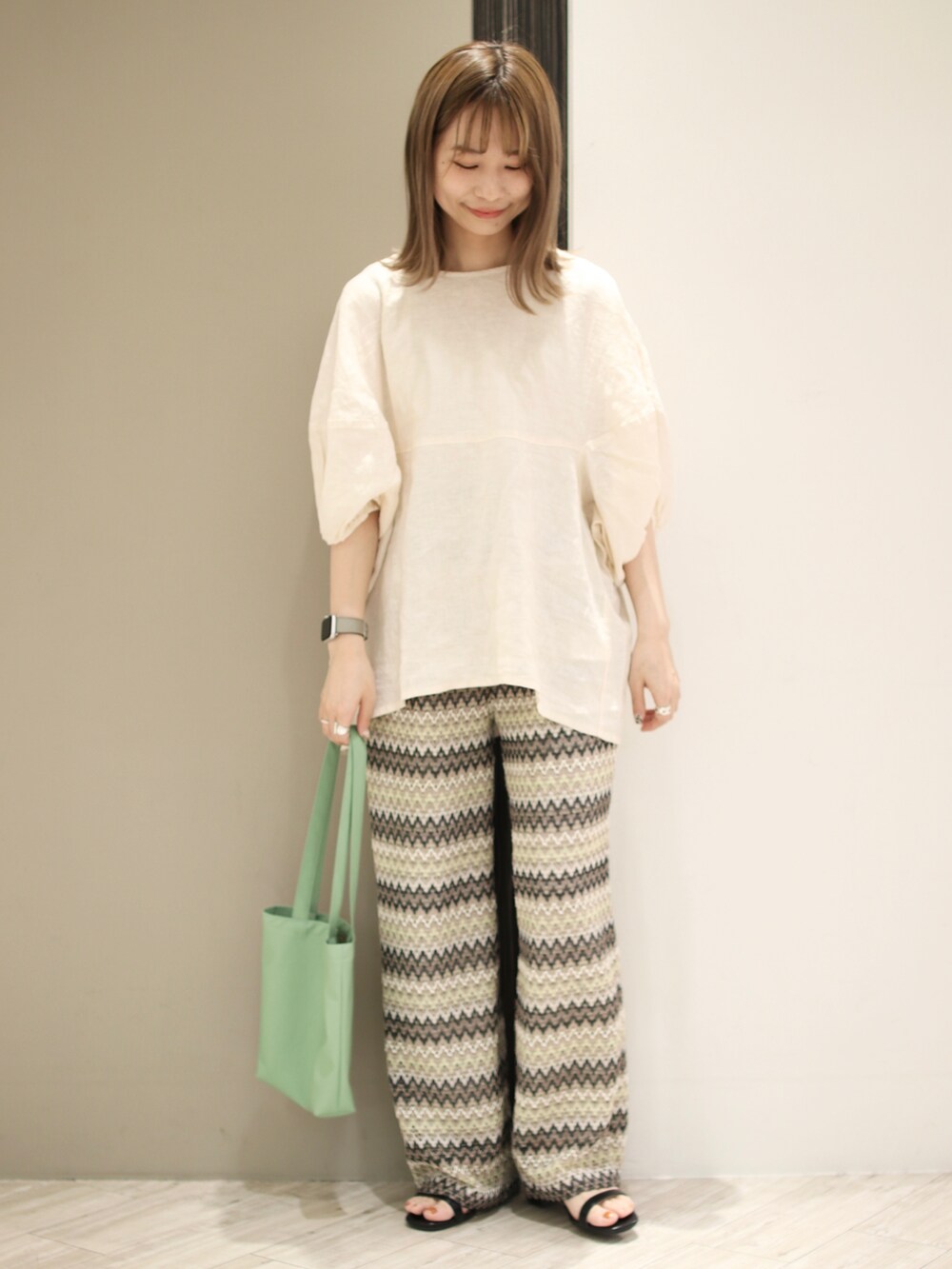 ベージュ系のシャツ/ブラウス、グリーン系のトートバッグ、ベージュ系のその他パンツを着用したレディースの春コーディネートの2枚目の写真