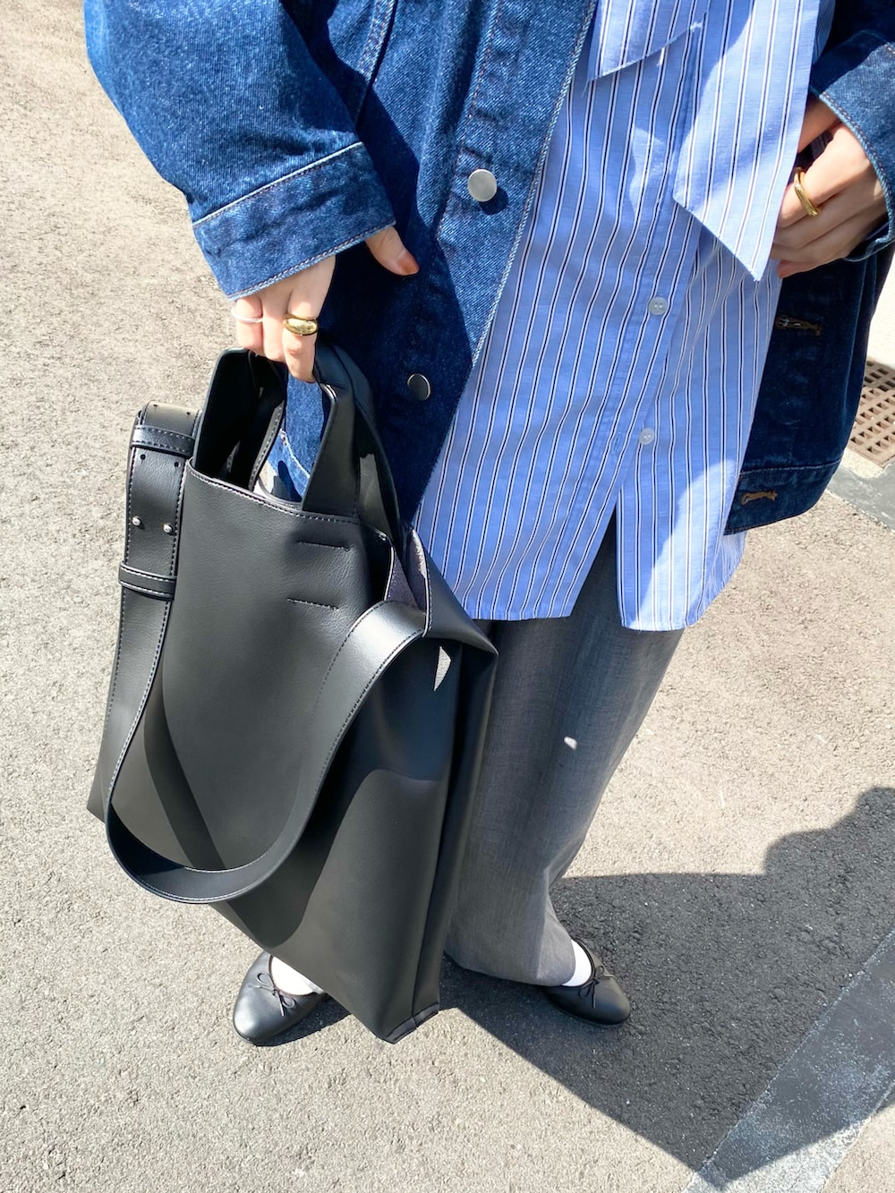 グレー系のパンツ、ブラック系のトートバッグ、ブルー系のシャツ/ブラウスを着用したレディースの春コーディネートの4枚目の写真