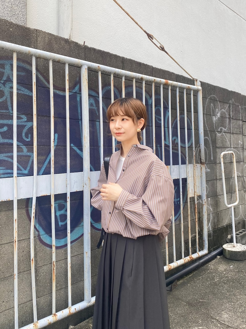 グレー系のスカート、ブラウン系のシャツ/ブラウス、ブラック系のローファーを着用したレディースの秋コーディネートの6枚目の写真