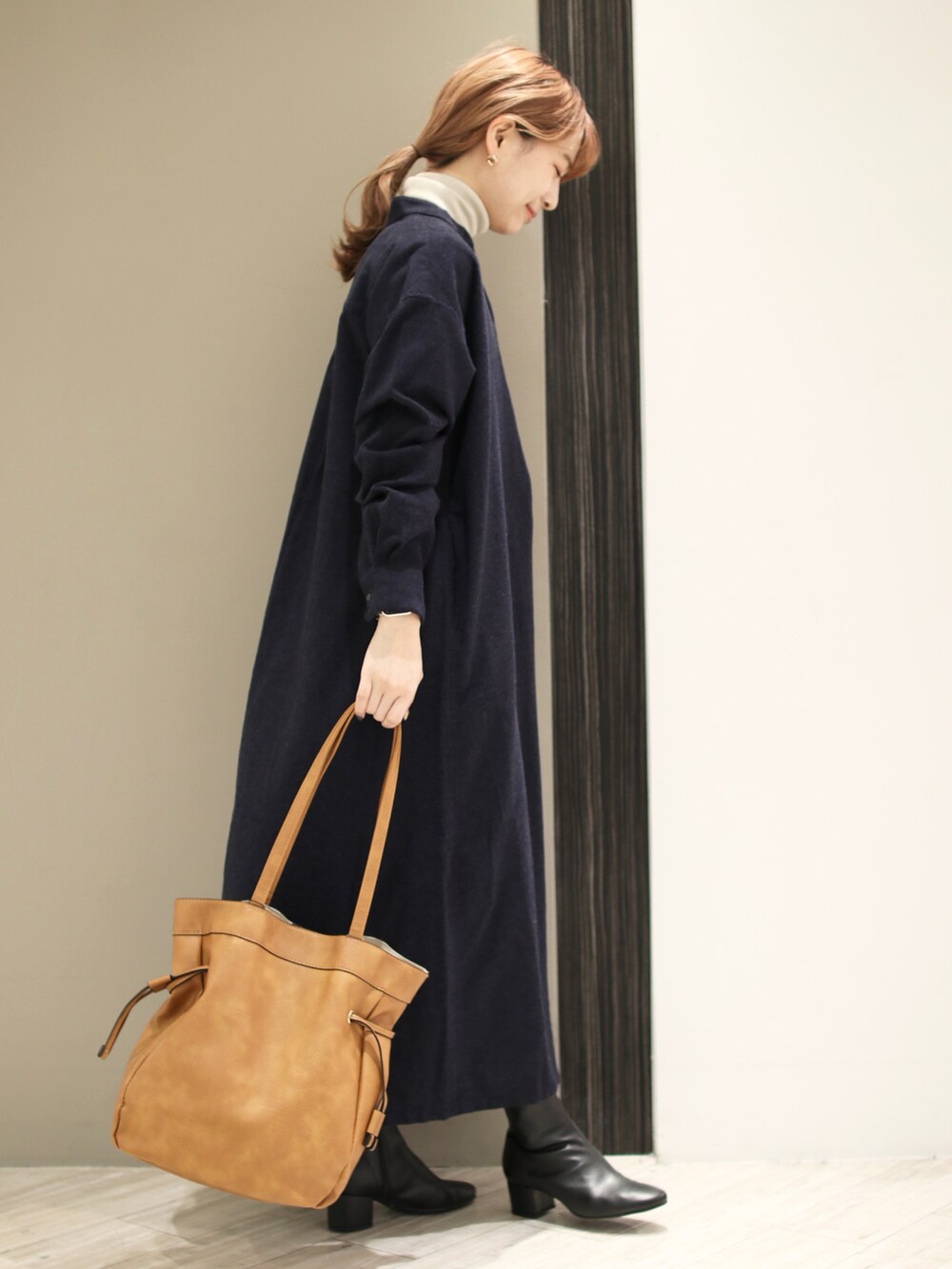 ブルー系のワンピース、ベージュ系のTシャツ/カットソー、ブラック系のブーツを着用したレディースの冬コーディネートの4枚目の写真