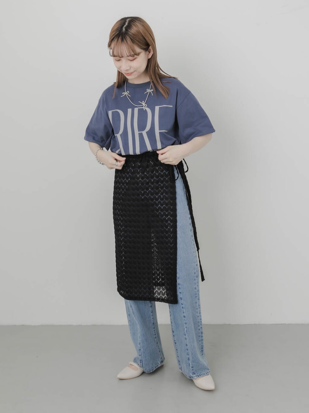 ブルー系のデニムパンツ、ホワイト系のパンプス、ブラック系のスカートを着用したレディースの夏コーディネートの2枚目の写真